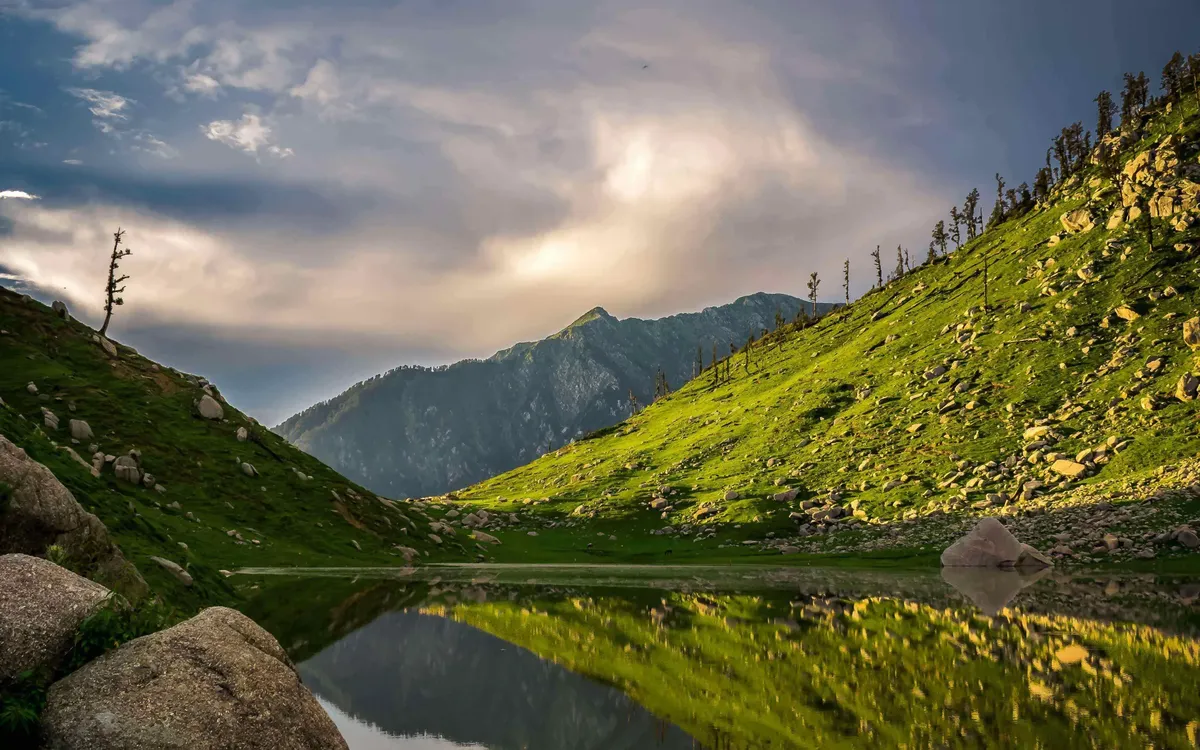 Kareri Lake mirroring the green slopes around it